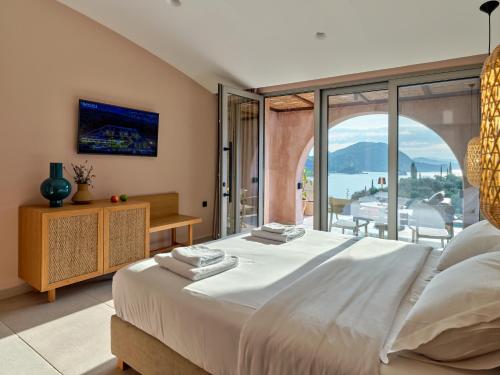 a bedroom with a large bed and a large window at ISAVORIA ECO CHIC RESORT in Parga