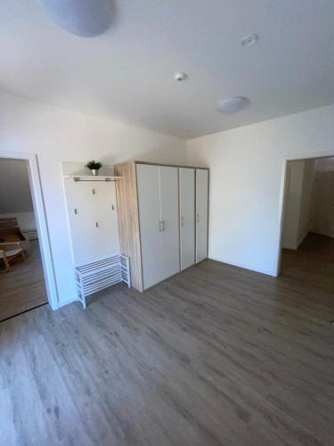 een lege kamer met witte muren en houten vloeren bij Gästehaus Landleben am Deich in Balje