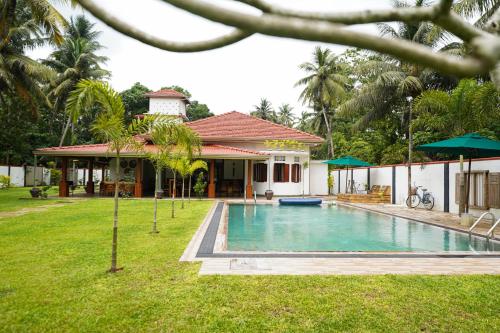 a house with a swimming pool in the yard at Cozy Villa in Hikkaduwa