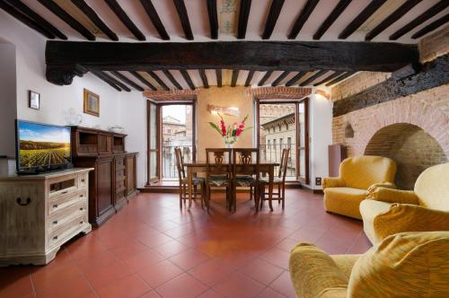 a living room with a table and a tv at Bargello Accommodation in Siena