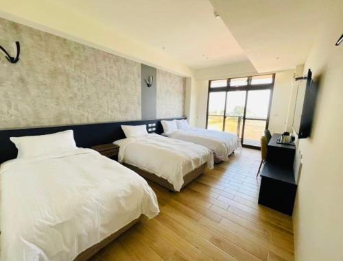ein Hotelzimmer mit 2 Betten und einem Fenster in der Unterkunft Zhuluowan Club in Insel Nangan