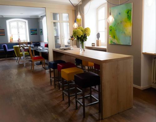a restaurant with a bar with chairs and a vase of flowers at Hotel Bergbauer mit Late-Self-Check-IN in Neuburg an der Donau