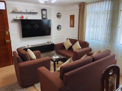 ein Wohnzimmer mit Sofas und einem Flachbildfernseher in der Unterkunft Apartamento en Primer Piso a 7 min del Centro Histórico in Trujillo