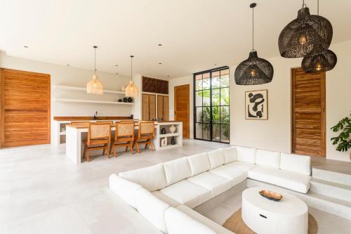 a living room with a white couch and a table at The Dreamland by The Young Villas in Uluwatu