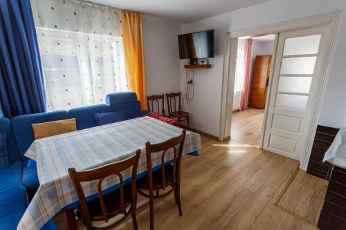 un salon avec une table et un canapé bleu dans l'établissement Casa De Vacanta Armi, à Molidu