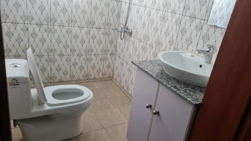 bagno con servizi igienici e lavandino di Room in Guest room - Charming Room in Kayove, Rwanda - Your Perfect Getaway 