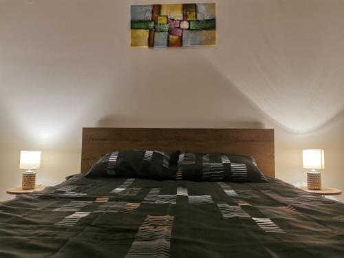 a bedroom with a large bed with two lamps at LoLa5 in Novi Grad