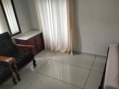 a living room with a chair and a window at Guestland Homestay in Cochin