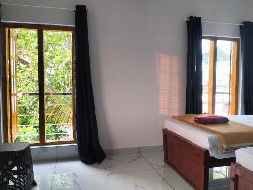a bedroom with a bed and a large window at Guestland Homestay in Cochin