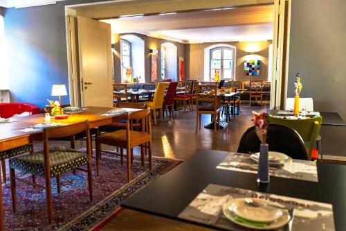 un comedor con mesas y sillas en un restaurante en Hotel Bergbauer en Neuburg an der Donau