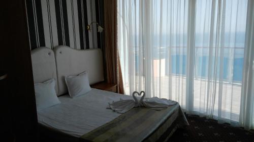 a bedroom with a bed and a large window at SPA Hotel Sirius Beach - FREE SPA access in St. St. Constantine and Helena