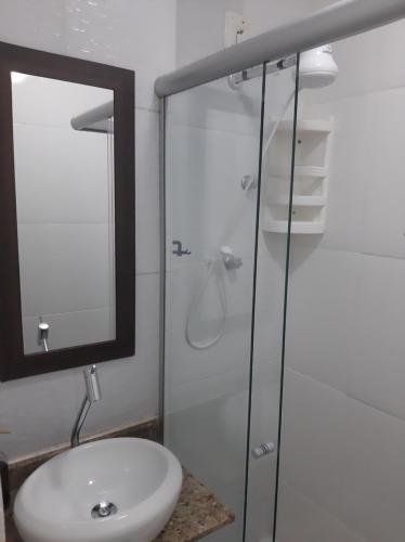 a bathroom with a sink and a glass shower at Loft aconchegante - Centro Niterói in Niterói