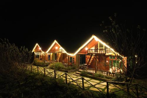 a house with lights on it at night at Himalayan Cedar Nest in Sainj