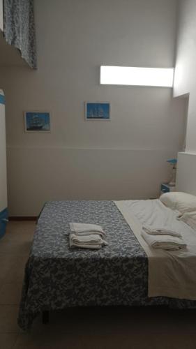 a bedroom with a bed with towels on it at Room34Trani in Trani