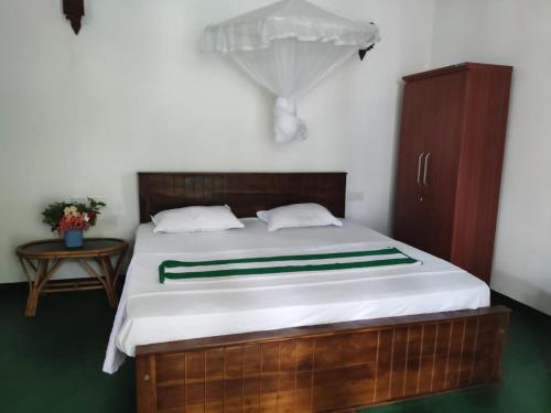a bedroom with a large bed with white sheets at Palm Beach Cabana in Kosgoda