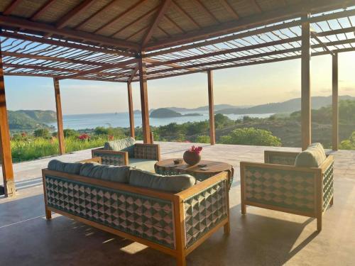 a patio with couches and a table with a view at Lobster Bay Lombok in Awang