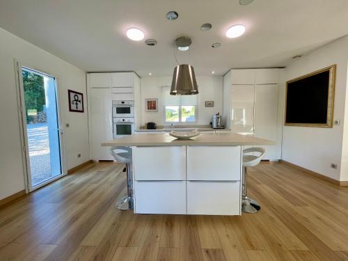 a kitchen with white cabinets and a large island at Villa Grey in Brignoles