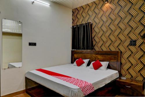 OYO Flagship Hotel RVR في بيلاسبور: غرفة نوم عليها سرير ومخدات حمراء