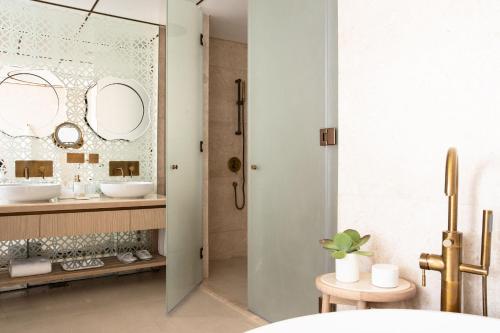 a bathroom with a sink and a shower with a mirror at Jumeirah Saadiyat Island Abu Dhabi in Abu Dhabi