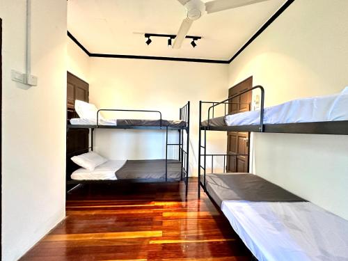 two bunk beds in a room with a ceiling at The Wooden Retreat by Elite Stay in Port Dickson