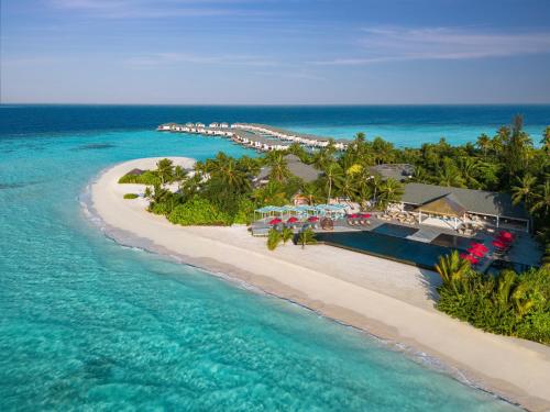 een luchtzicht op een strand met een resort en de oceaan bij NH Collection Maldives Havodda Resort in Gaafu Dhaalu Atoll