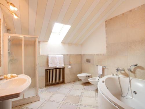 ein Badezimmer mit einer Badewanne, einem WC und einem Waschbecken in der Unterkunft Poggio Radicati Hotel De Charme in Saluzzo