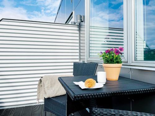 a table with a plate of food on a balcony at athome apartments in Aarhus