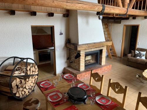 a living room with a table and a fireplace at Chalet Le Remarquable, Crest Voland in Crest-Voland