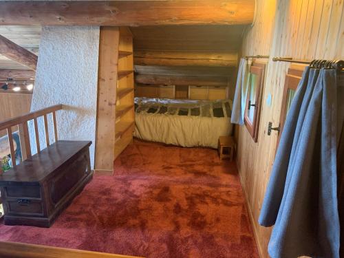 a room with a bed in a log cabin at Chalet Le Remarquable, Crest Voland in Crest-Voland