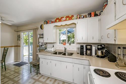 una cocina con armarios blancos y fregadero en Beautiful Comfy & Relaxed Basement Room - Great Location C4 en Surrey