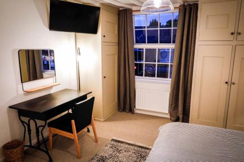 a bedroom with a desk and a bed and a window at The Wine Loft in Quorndon