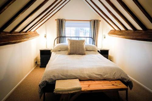 a large bed in a room with a window at The Wine Loft in Quorndon
