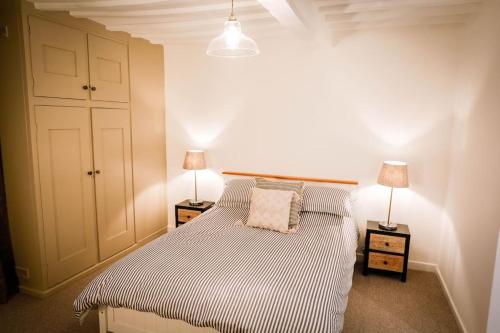a bedroom with a bed with two night stands and two lamps at The Wine Loft in Quorndon