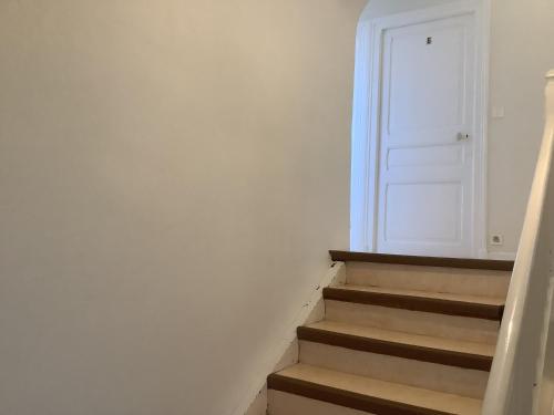 a stairway with a white door and some stairs at Le village Gr34 louannec in Louannec