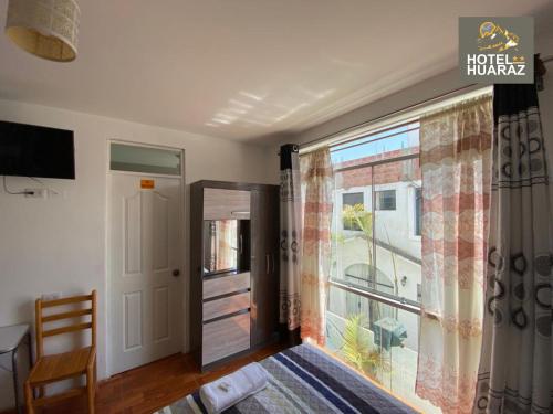 1 dormitorio con cama y ventana grande en HOTEL HUARAZ, en Tacna