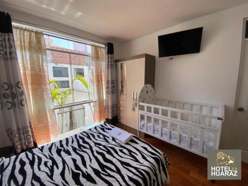 a bedroom with a zebra print bed and a window at HOTEL HUARAZ in Tacna