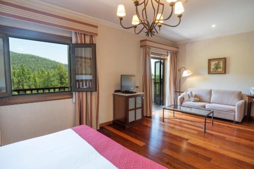 a room with a bed and a couch and a window at Hotel Spa Villalba in Vilaflor