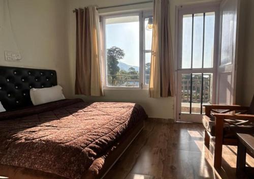 1 dormitorio con cama y ventana grande en Gliders Inn by Barefoot Inc en Bīr