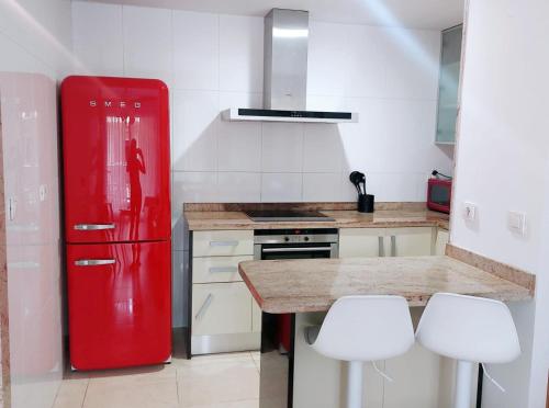 een keuken met een rode koelkast en 2 witte stoelen bij BEACH VALENCIA 29 - Luxury Beachfront Apartament in Valencia