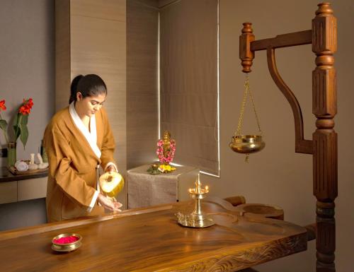 a woman standing in a room with a table with candles at O by Tamara Coimbatore in Coimbatore