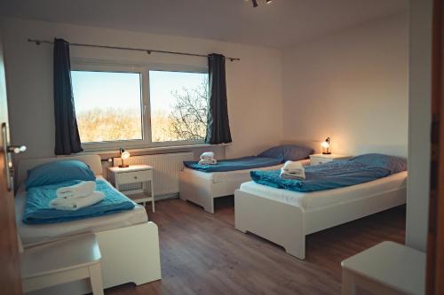 Rabenkirchen-FaulückにあるFerienhaus Ostseeのベッド2台と窓が備わる客室です。