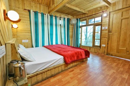 ein Schlafzimmer mit einem Bett in einer Holzhütte in der Unterkunft Himalayan Cedar Nest in Sainj