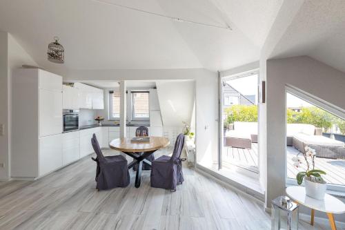 a kitchen and dining room with a table and chairs at Penthouse with Whirlpool Central in Düsseldorf