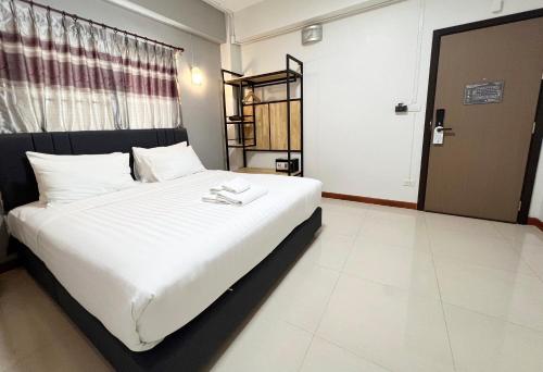 a bedroom with a large bed with white sheets at Golden Nest Hotel Suvarnabhumi in Bangkok