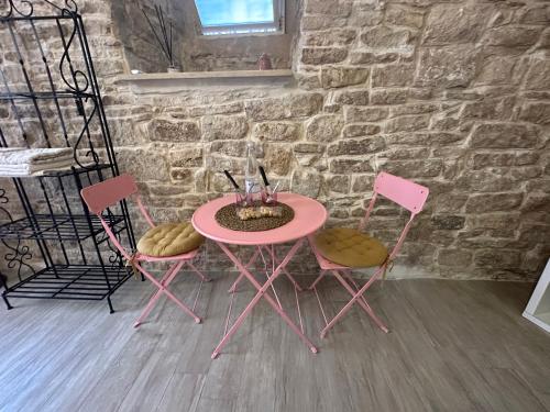 a pink table with two chairs and a table with a bowl at Giovinazzo Suite Spirito Santo in Giovinazzo