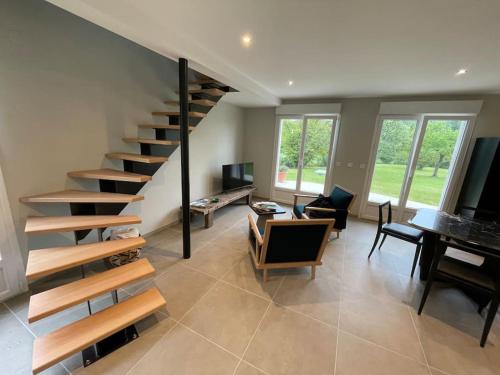 a living room with a spiral staircase in a house at Gite le3chênes in Remoncourt