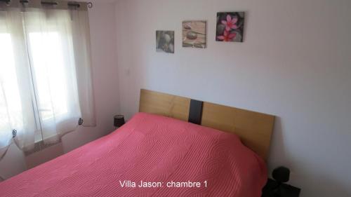 une chambre avec un lit avec une couverture rose dans l'établissement Jason, à Cervione
