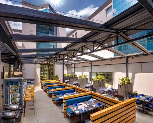 a restaurant with blue tables and yellow chairs at O by Tamara Coimbatore in Coimbatore