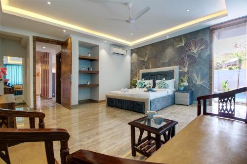 a bedroom with a bed and a living room at Euphoria Luxury Villa - 5BHK - Private Pool - Jacuzzi, Baga in Baga