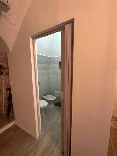 an open door to a bathroom with a toilet at Giovinazzo Suite Spirito Santo in Giovinazzo